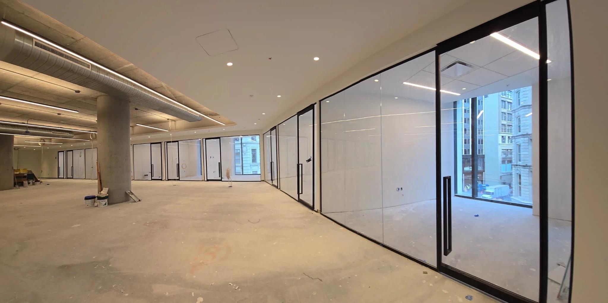 Bright glass-walled space mid-construction